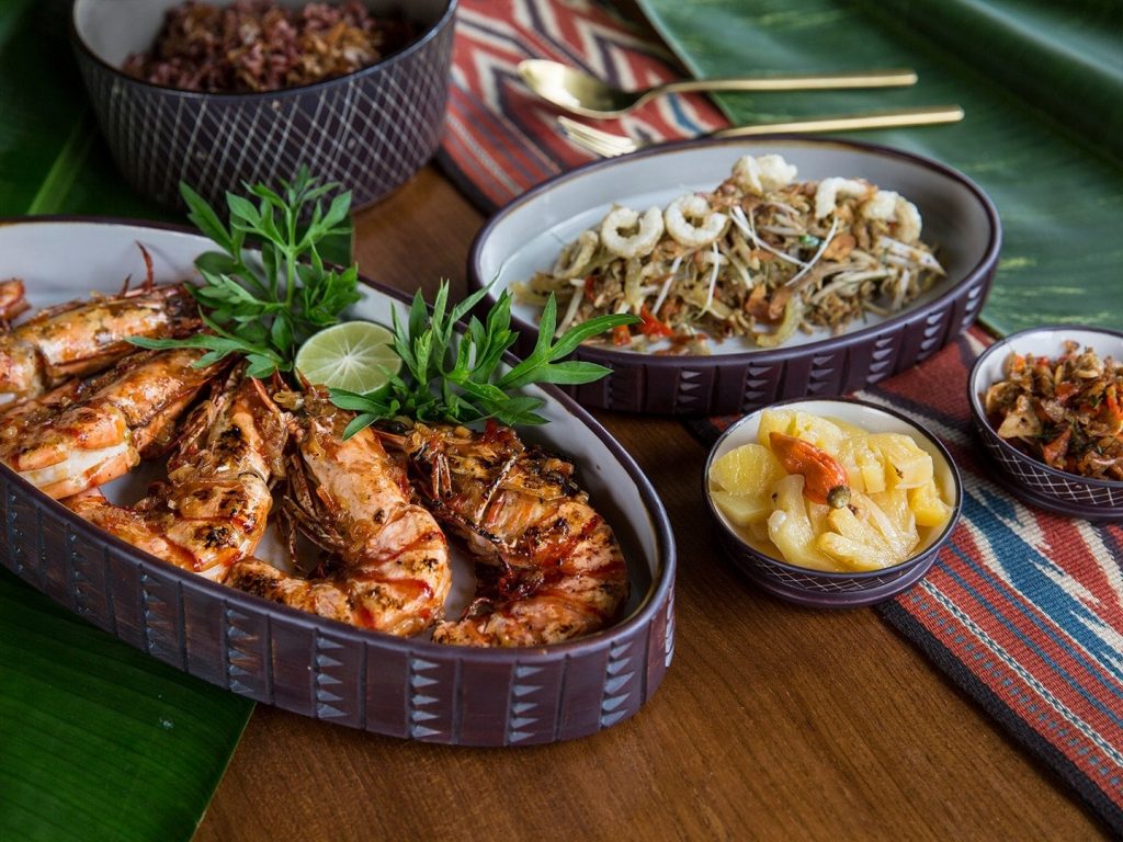 Grilled jumbo prawns with pickled spicy pineapple and red rice is a dish served at Kaum, located in Seminyak, Bali.