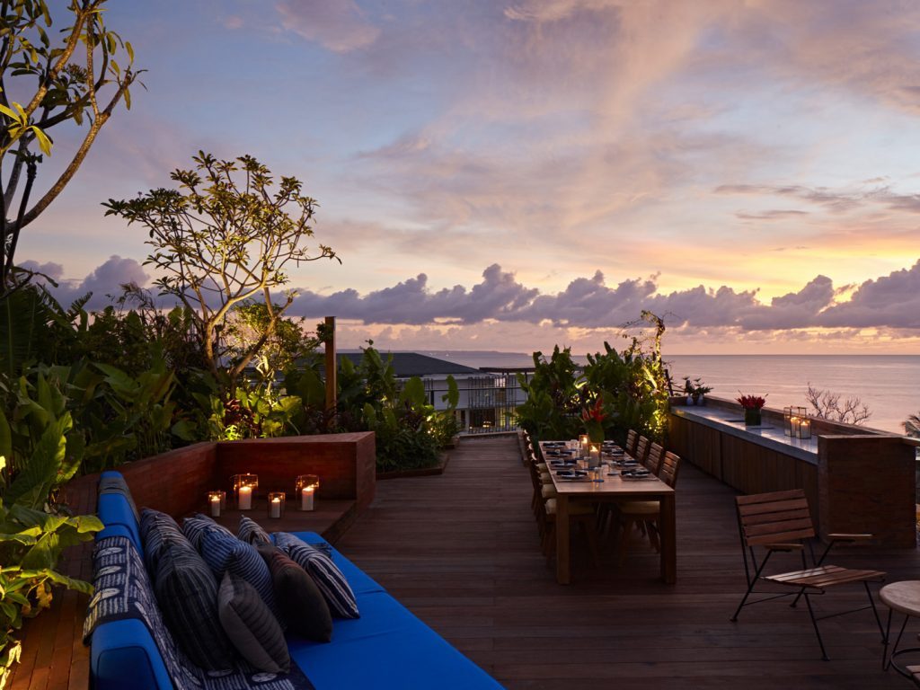 Private rooftop deck at the Potato Head Suites in Seminyak, with seating and dining area overlooking stunning ocean views.