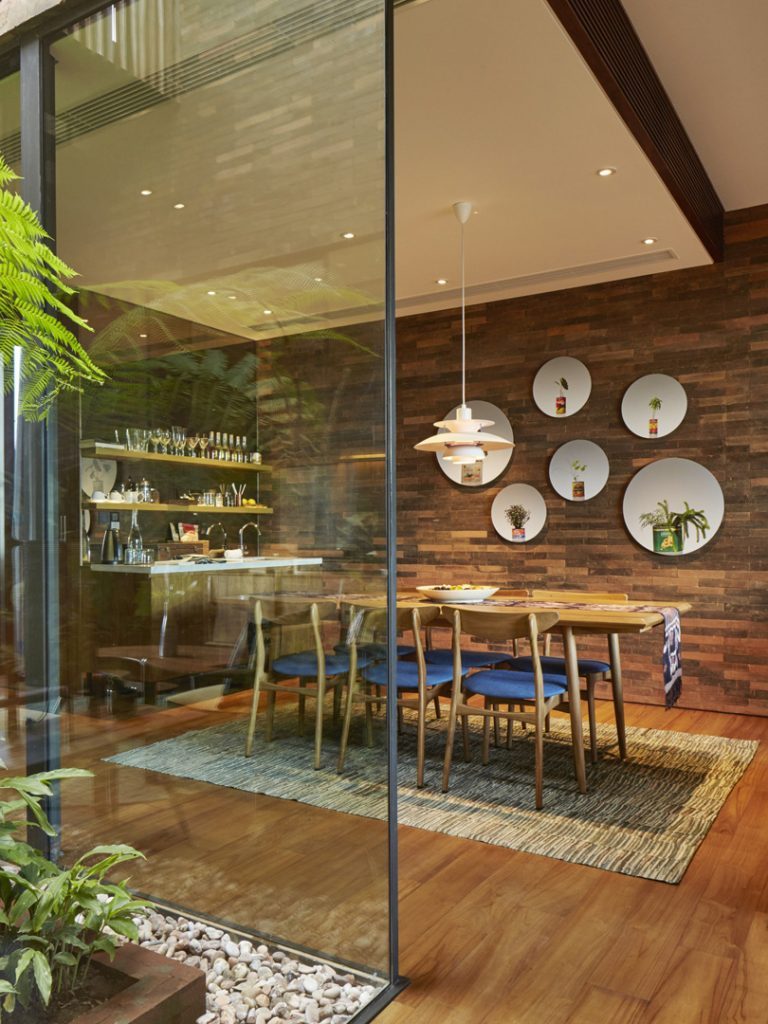 The dining area in the Rooftop Suite at Potato Head Suites is right next to the in-room bar and has clear glass windows.