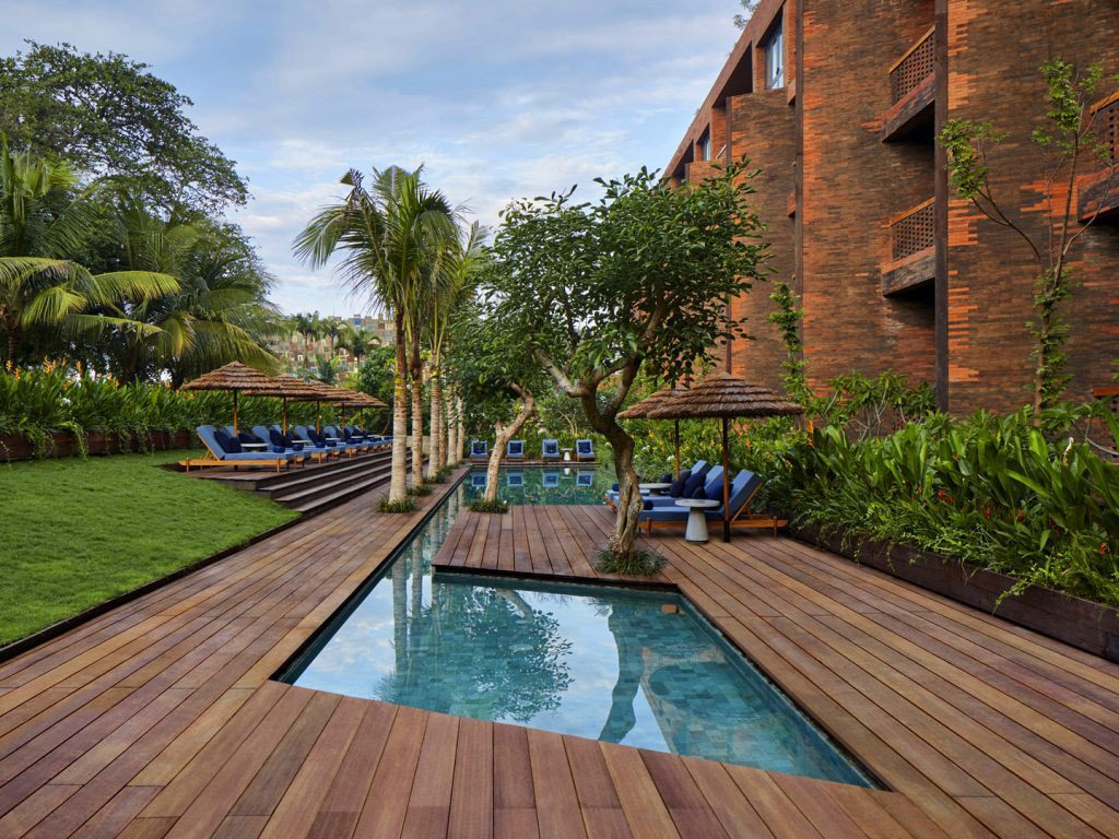 Outdoor pool area with sheltered recliners at the luxurious Potato Head Suites located in Desa Potato Head in Seminyak, Bali.