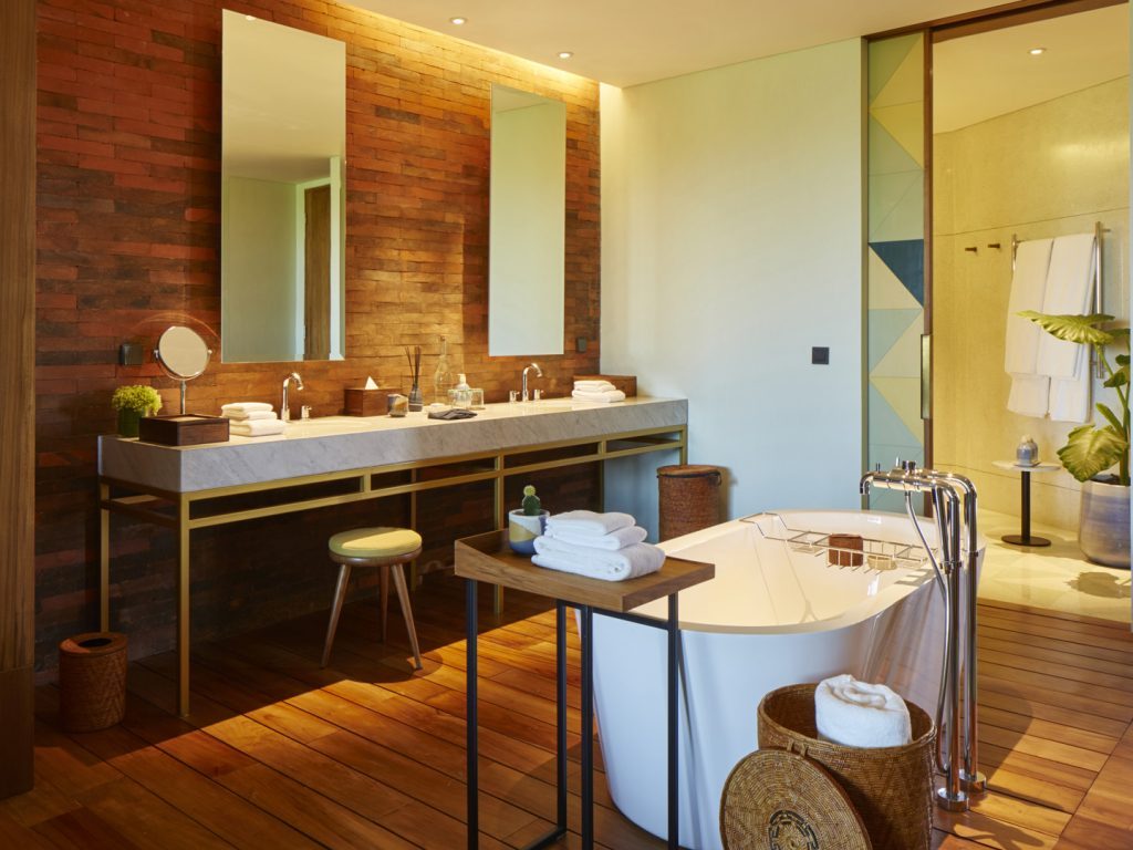 The bathroom in the Two Bedroom Suite at Potato Head Suites features a double sink and a bathtub.