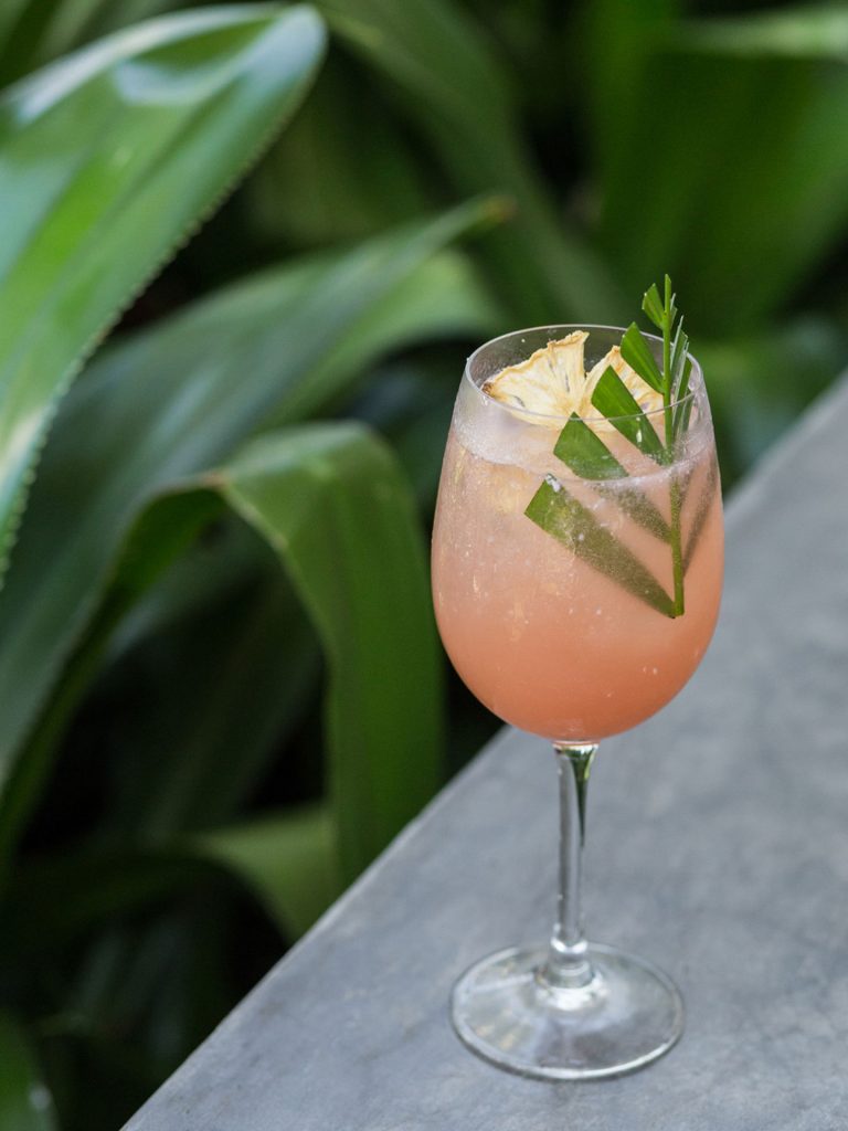Sundown Spritz, a coconut and pink citrus cocktail served in a tall glass at the Potato Head Beach Club in Seminyak, Bali.