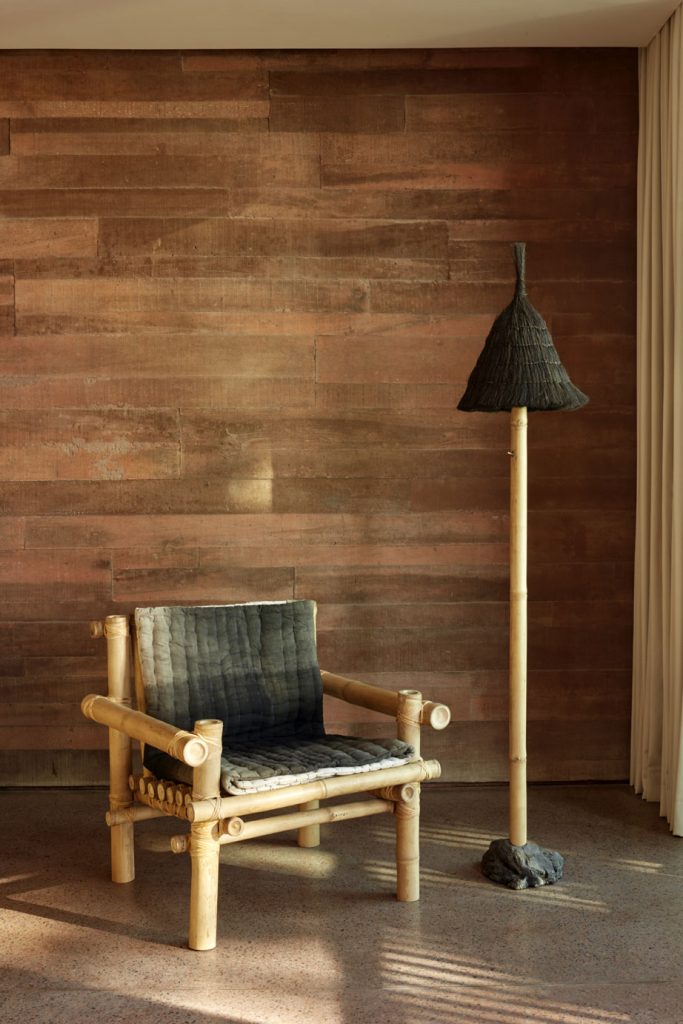 A bamboo arm chair with a matching standing lamp in one of the studios at the Potato Head Studios in Seminyak, Bali.