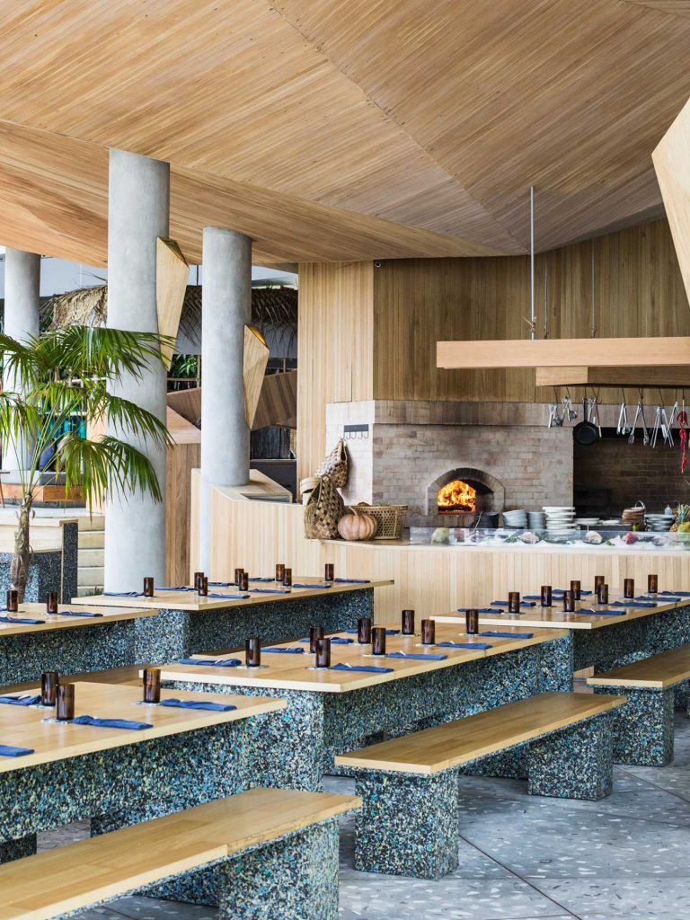 The interior of Ijen, a seafood restaurant in Seminyak, Bali which has long tables and an open fire to cook fresh seafood.
