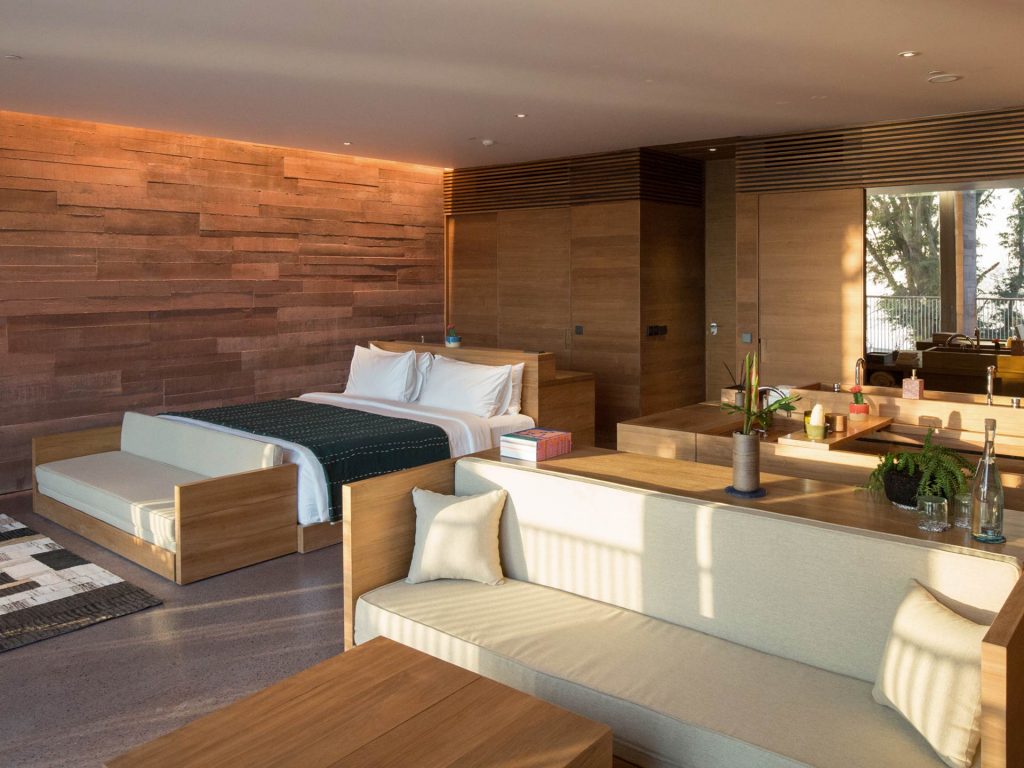 The open-concept interior of the Oceanfront Studio at Potato Head Studios features the bedroom, living area and bathroom.